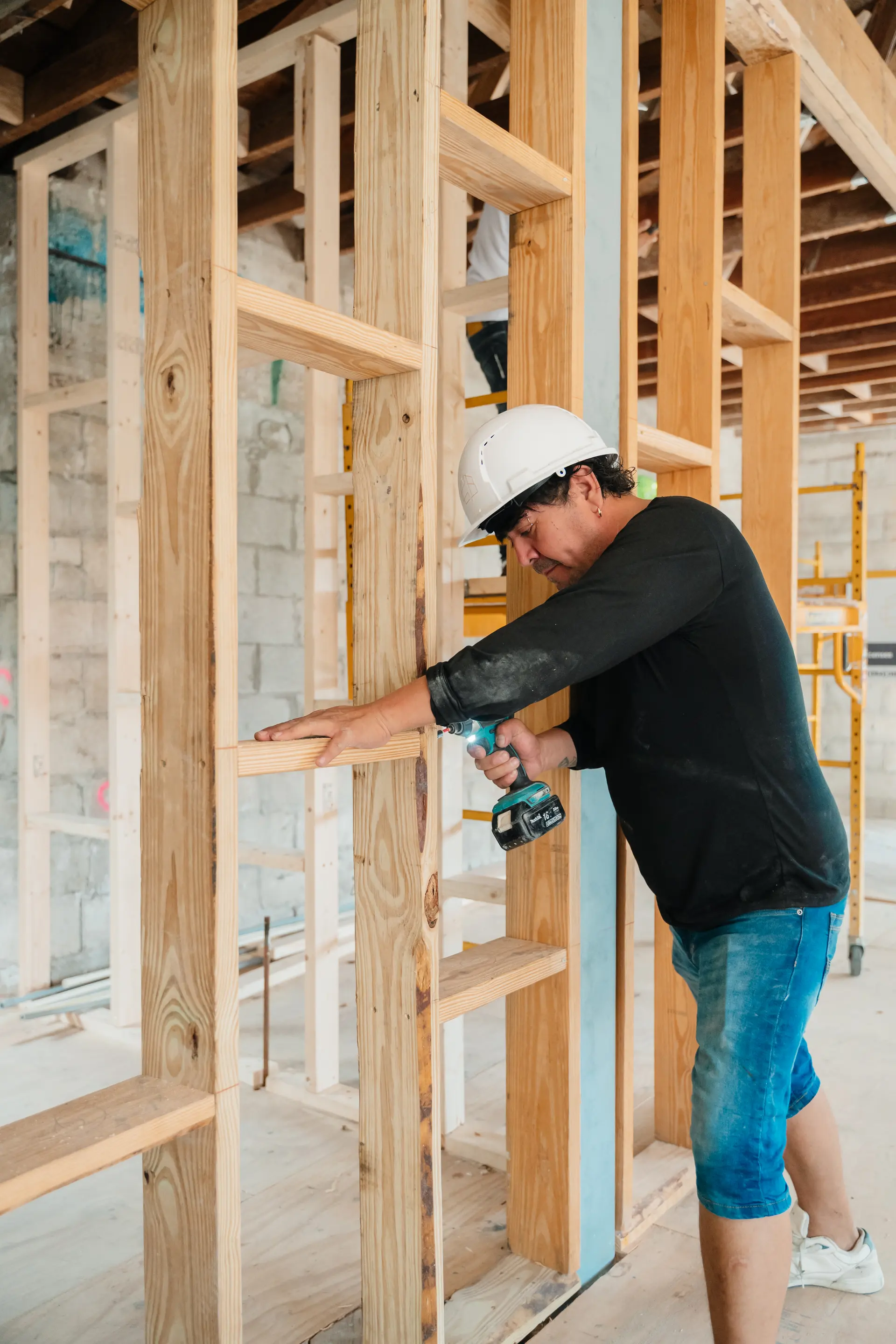 Worker installing structural framing during a custom home build